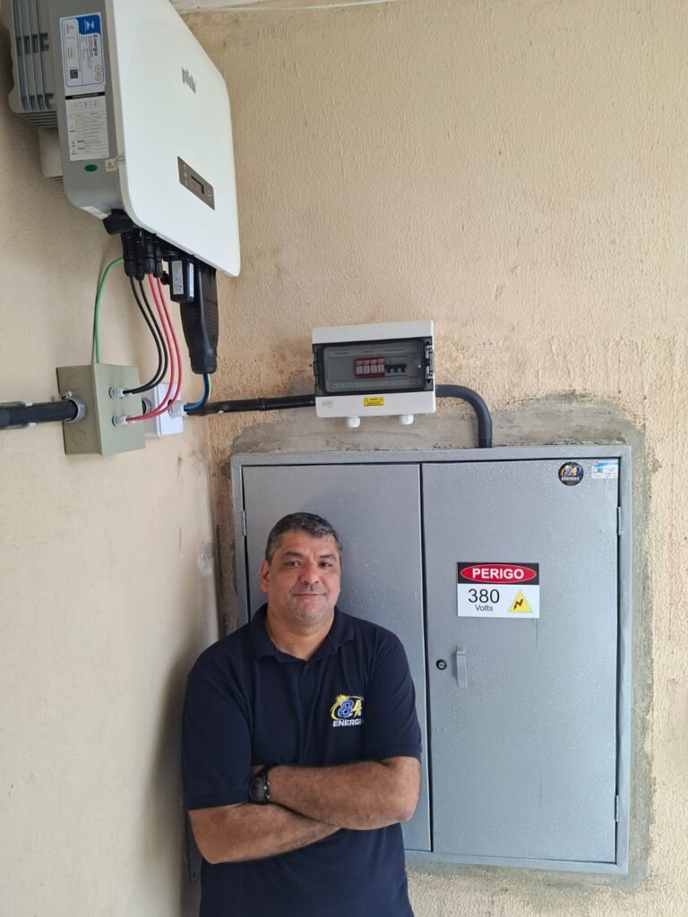 Engenheiro eletricista Carlos Eduardo, da 84 Energia, ao lado do inversor e do quadro elétrico